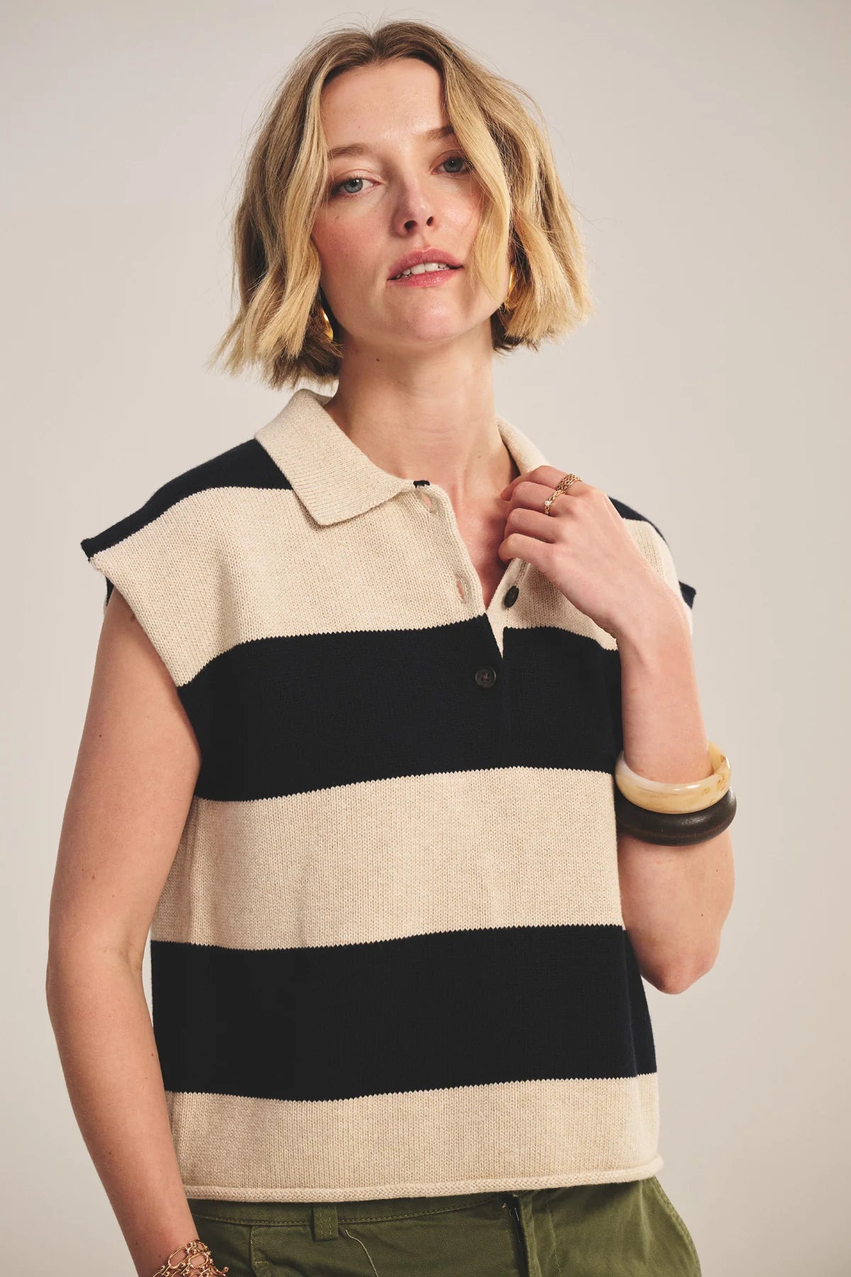 Woman wearing a sleeveless striped shirt with a neutral background
